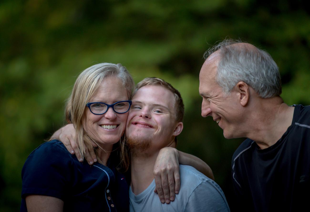 a photograph of a family hugging eachother and facing the camera